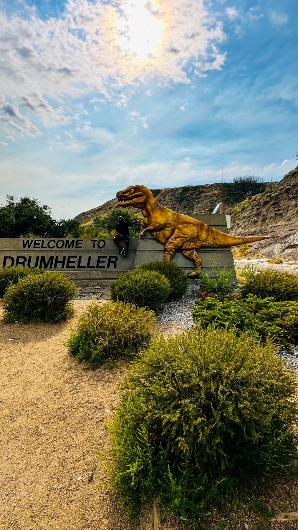 A playful roadside stop at the Drumheller dinosaur sign